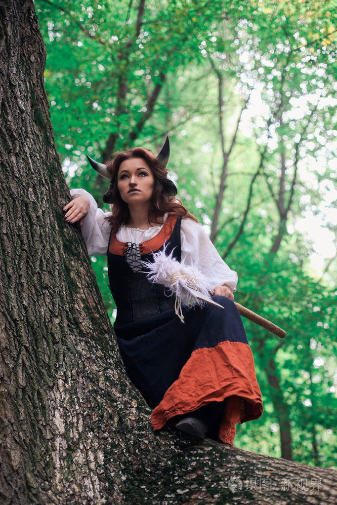 一个迷人的年轻红发女孩公主与牛的角的画像牛在魔法森林幻想童话故事