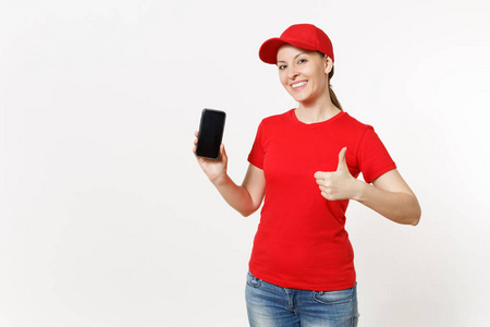 送妇女在红色制服被隔绝在白色背景。女性在帽, t恤, 牛仔裤工作作为信使或经销商显示在相机手机与空白的空屏幕。复制空间广告