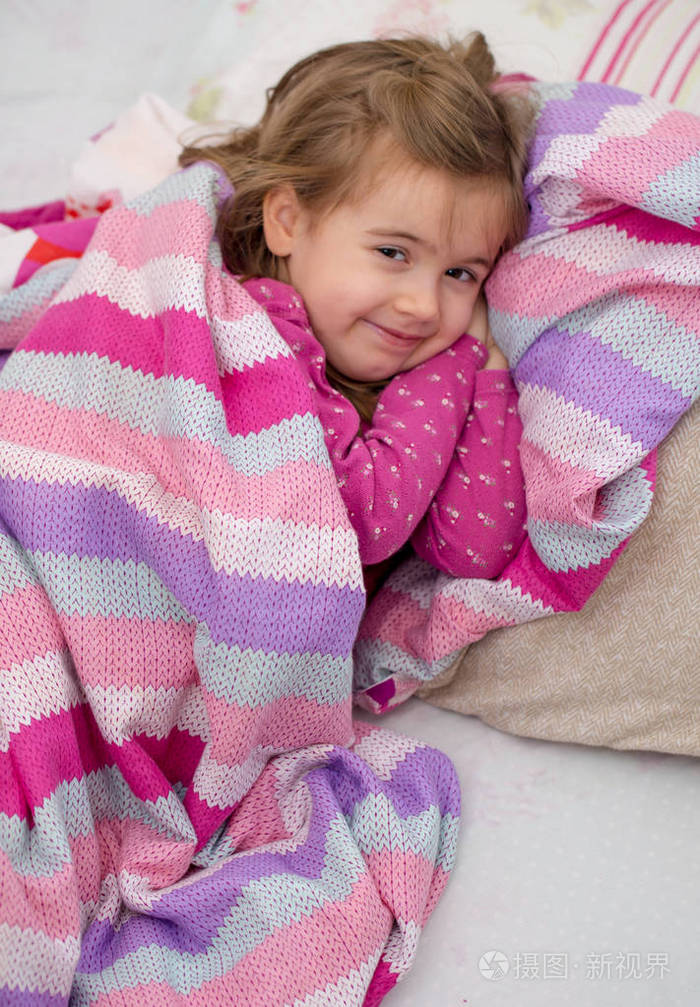 在粉红的床上睡觉的小女孩