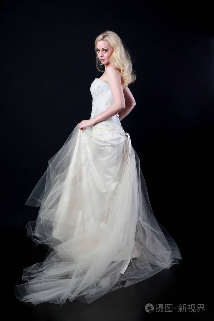 穿白色新娘礼服的模特全长肖像, 黑色背景站立姿势