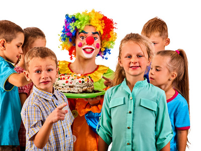 生日儿童小丑和孩子一起玩。刚出生的节日蛋糕庆祝