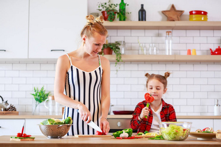 妇女与女儿在厨房切菜的图片