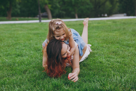 女主被草得很爽快乐的女人穿着浅色的衣服和可爱的小女孩躺在绿色草地