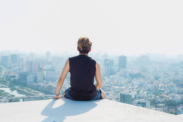 一个人坐在楼顶的照片图片