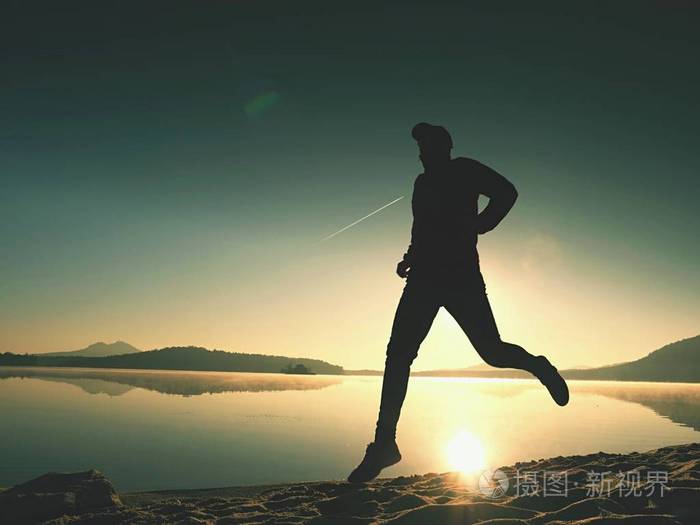 人在日落时分在沙滩上跳跃