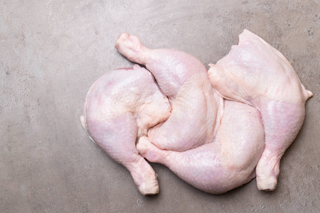 在灰色背景下设置四只生鸡腿.减肥肉照片