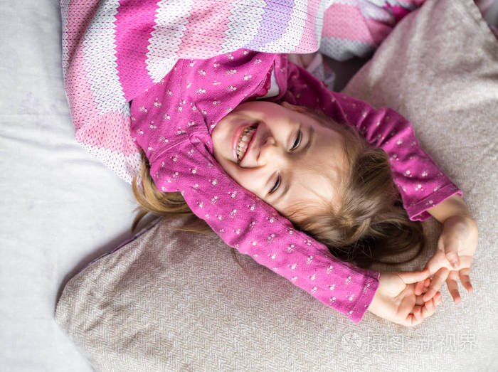 在粉红的床上睡觉的小女孩