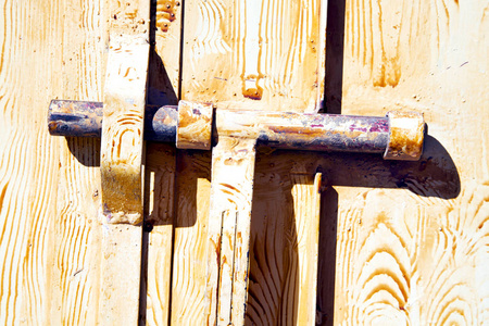 棕色摩洛哥非洲旧的木立面回家和生锈的安全挂锁