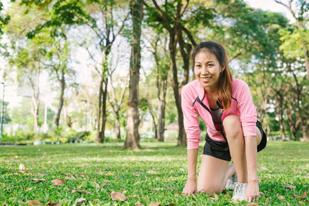 马克的亚洲年轻女子准备做慢跑运动, 在温暖的晨光中, 在玻璃上 buld 她的身体。年轻女子在公园做运动锻炼, 使身体美观。公园