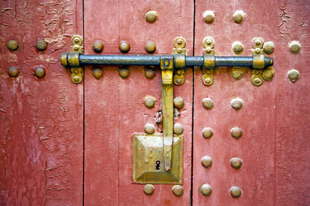 棕色摩洛哥非洲旧的木立面回家和生锈的安全挂锁