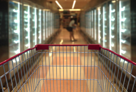 在超市的走道上与产品货架上的购物车视图