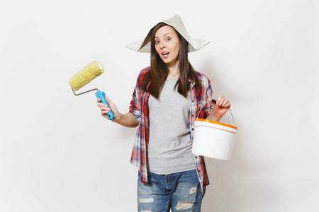 报纸的帽子有关妇女在报纸帽子持有油漆辊为墙壁绘画和空的油漆桶与