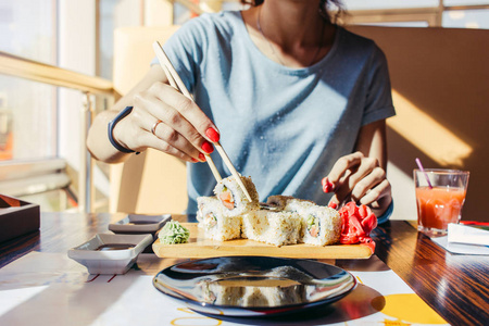 夏印章穿蓝色衬衫的女人吃夏治一家寿司店照片