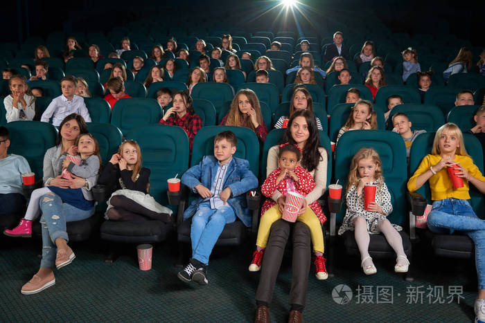 儿童与父母正一起在电影院看电影