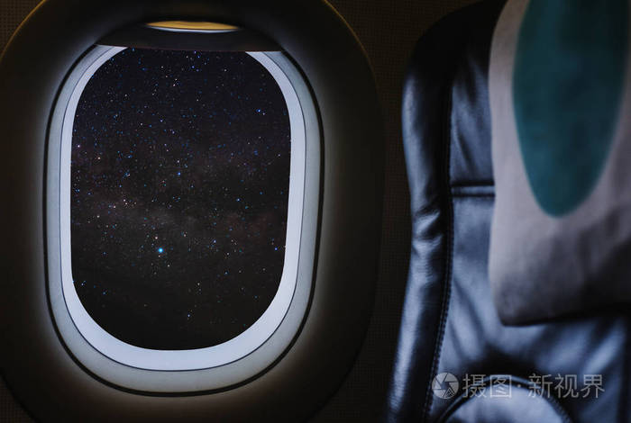 乘飞机旅行透过平面窗口欣赏夜空中充满繁星和银河的美丽夜空