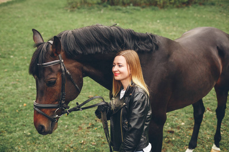 美丽的女孩与一匹马在公园里进行通信