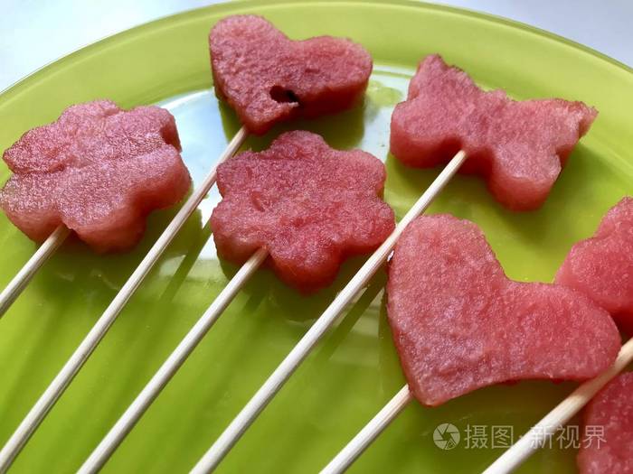 西瓜的果肉是用邮票切碎的.它们被赋予不同的形式.在烤肉串上的弦