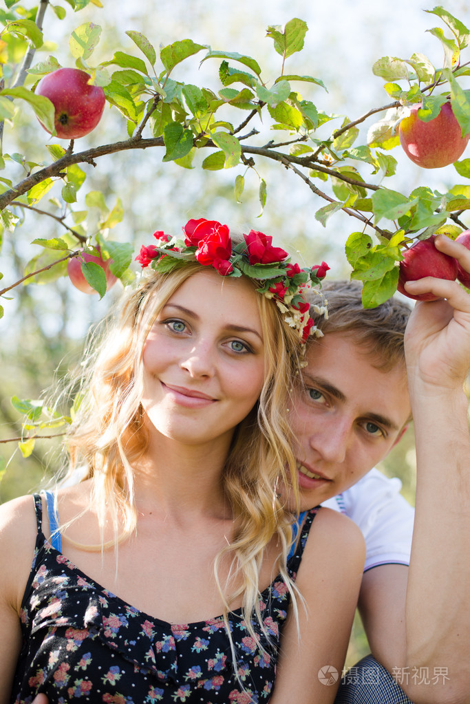 在秋天的果园中拥抱幸福小两口的特写图片