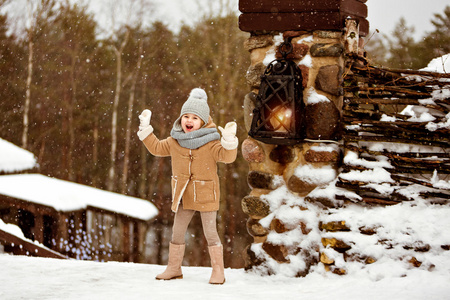 很甜漂亮女孩的小孩子在米色的外套带着笑容照片