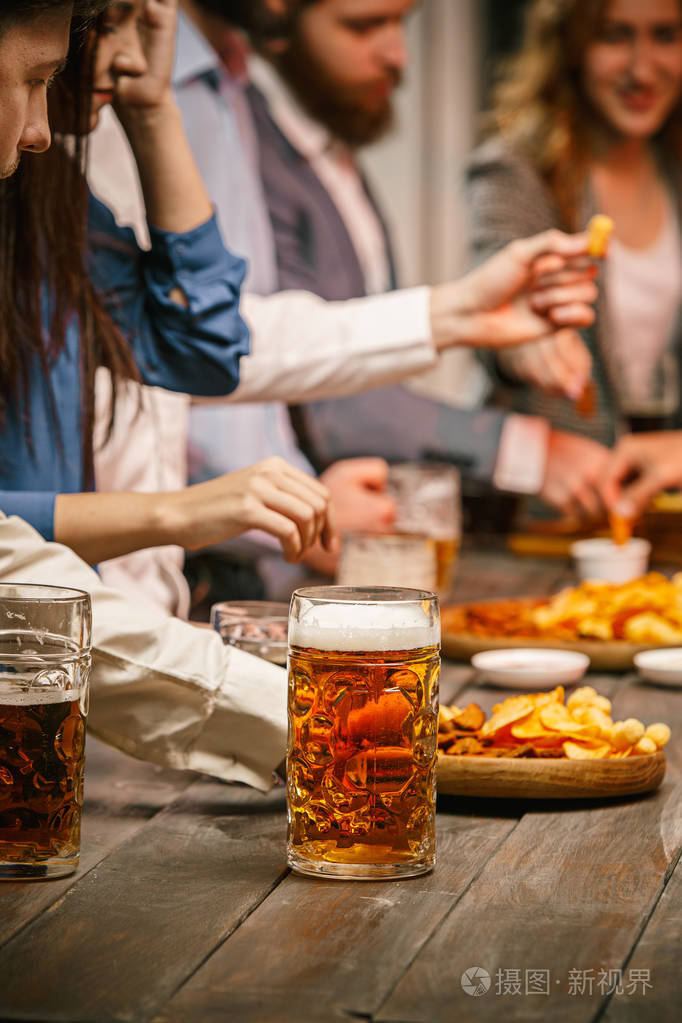 群的朋友享受晚上喝啤酒照片-正版商用图片0ouuhn-摄图新视界