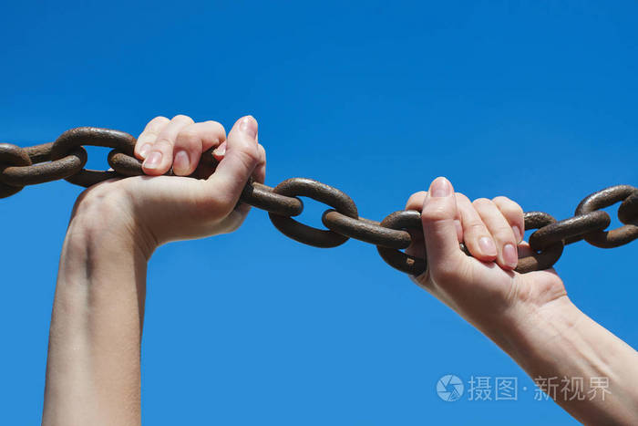 女人的手在蓝色背景特写上保持铁链子