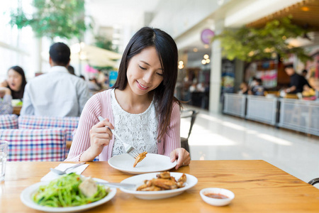 女人享受她在餐厅的食物