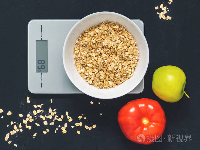 燕麦片在厨房秤上的白色盘子里.称重产品.早餐, 高级房