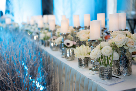婚礼的装饰。蜡烛烛台和玫瑰。蓝色背景