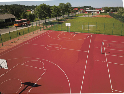 现代篮球场在小学的庭院。多功能儿童游乐场用人工表面围栏栅栏。儿童和青少年的体育教育场所