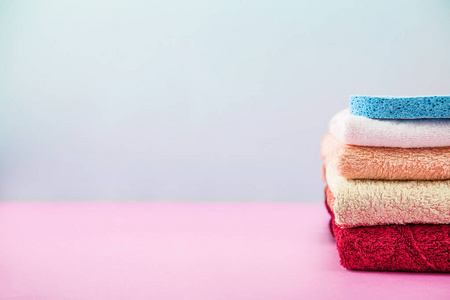 浴缸配件毛巾折叠, 堆放在一盏灯, 明亮的蓝色和粉红色的背景下, 照顾自己的概念, 你的身体。复制空间
