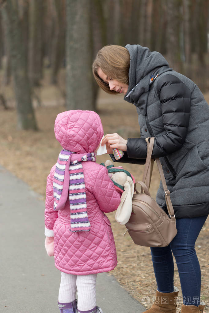 母亲为她的女儿在露天照顾