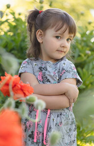 一个三岁小女孩的肖像在花园与红色的花朵