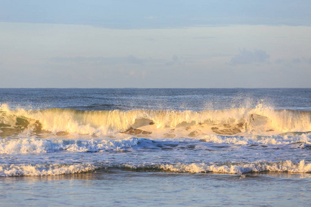 在日落海滩破碎波浪