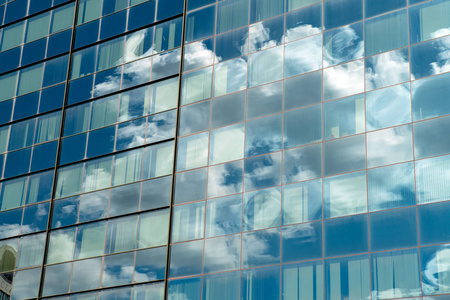 窗外大楼现代工业建筑用玻璃.蓝天与窗外的云彩的倒影照片