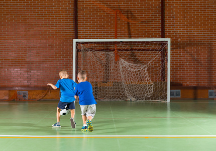 两个年轻男孩朋友踢足球