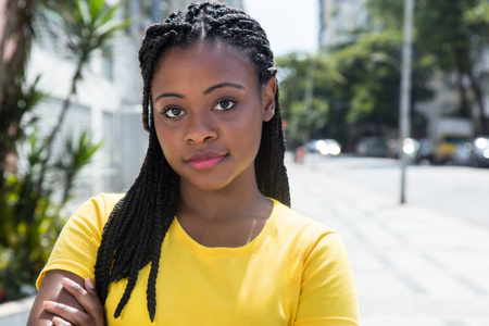 在城市的黄色衬衫的微笑非洲裔美国妇女