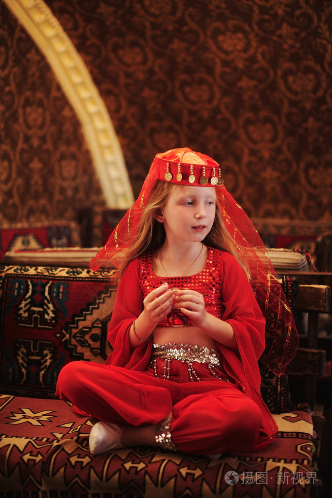 在土耳其喝茶的阿拉伯文服装的女孩