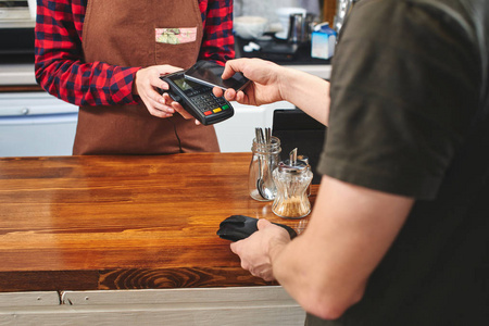 男性客户支付咖啡咖啡馆的女人与智能手机