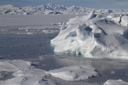 冰浮冰和一个小冰山困在海洋附近的一个小岛在南极