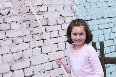 小女孩用滚筒和油漆油漆墙壁