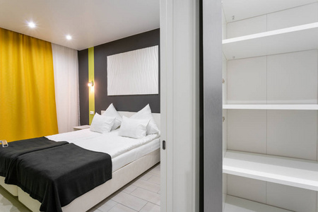 酒店斯坦达特房间。带白色枕头的现代卧室。简单时尚的内饰。室内照明