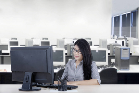 亚洲女商人坐在办公室里使用电脑的形象
