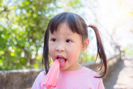 小亚洲女孩在公园吃冰淇淋