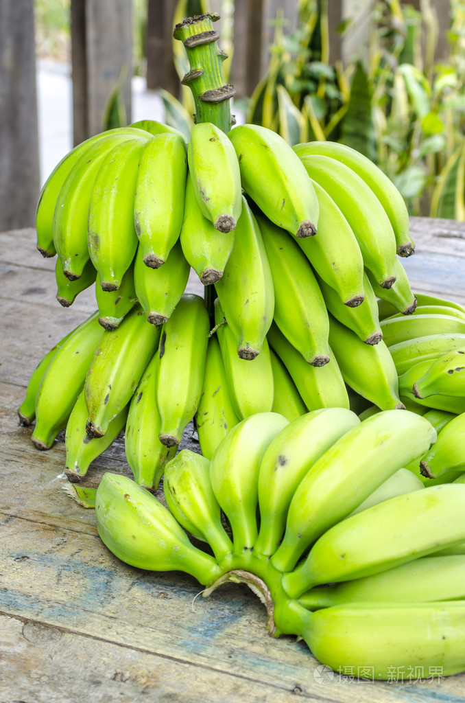 在一张木桌上的绿色香蕉