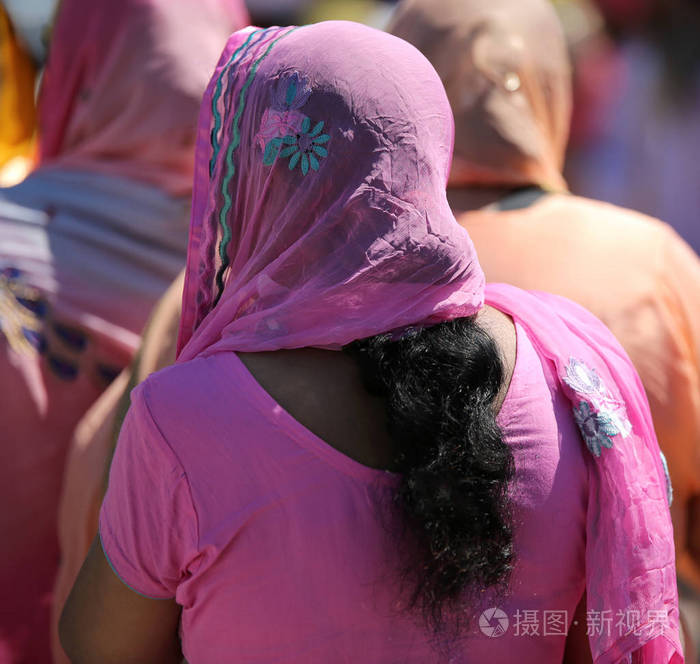 年轻的锡克女孩在宗教游行期间长黑头发和粉红色面纱