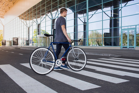 年轻时髦与复古自行车在人行横道上行走照片