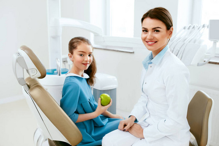 牙科诊所。女牙医和小病人吃苹果