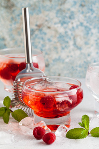 夏天酒精饮料与树莓甜酒, 冰和叶子新鲜薄荷在桌上。酒吧配件