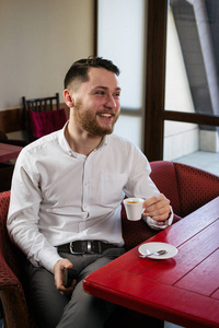 快乐的年轻人坐在咖啡馆，一杯咖啡