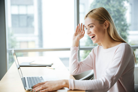 快乐的女人坐在办公室使用笔记本电脑时 coworking